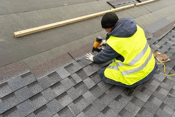 Roofer installing shingles on a residential roof in Cincinnati